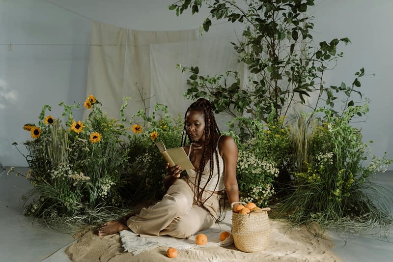 Alt text: Woman surrounded by various fresh herbs, symbolizing the integration of herbal medicine in psychiatric care.
